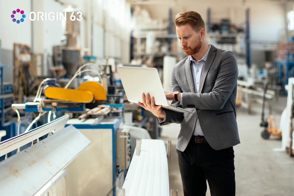 businessman-in-suit-working-on-laptop-in-manufacturing-plant
