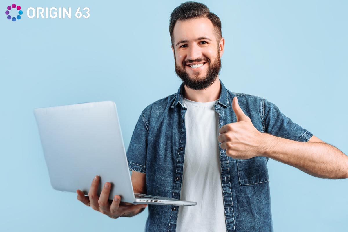  a-man-standing-holding-a-laptop-giving-a-thumbs-up